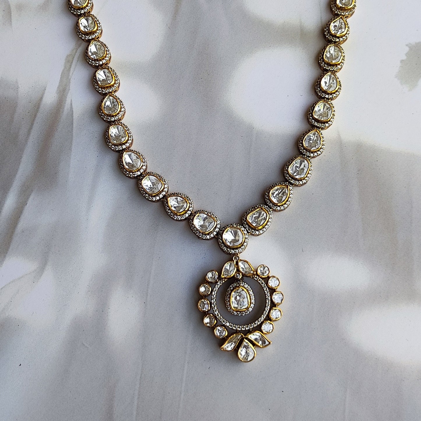"Heritage Polki halo Necklace in gold polished silver with teardrop and round stons by Arka Jaipur","Traditional handcrafted Polki Necklace with CZ detailing from Arka Jaipur","Designer Indian Polki dangler earrings in circular halo design by Arka Jaipur"