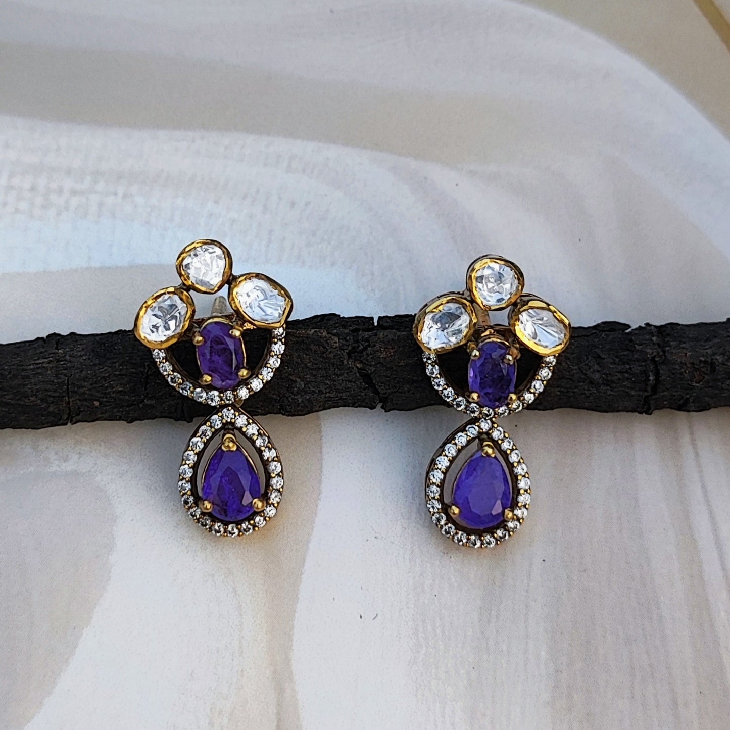 Handcrafted Violet Majesty gold-plated earrings with violet teardrop stones and polki crystals by Arka Jaipur. Perfect for weddings, parties, and festive elegance.