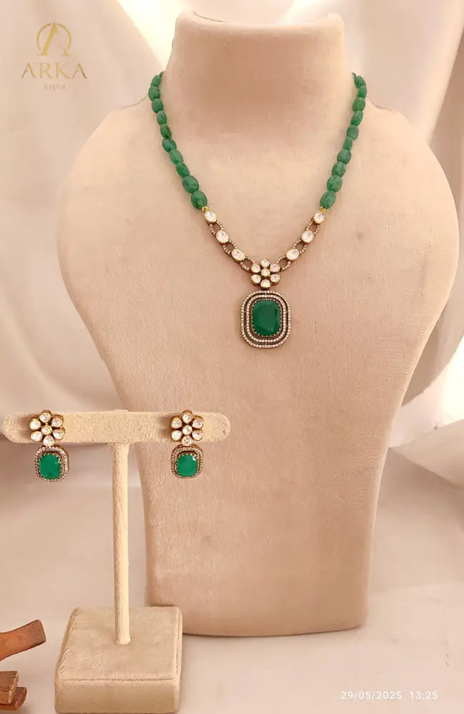 "Emerald blossom set necklace and earring set by Arka Jaipur featuring floral crystal designs and central green stone pendant – traditional Indian jewelry set"