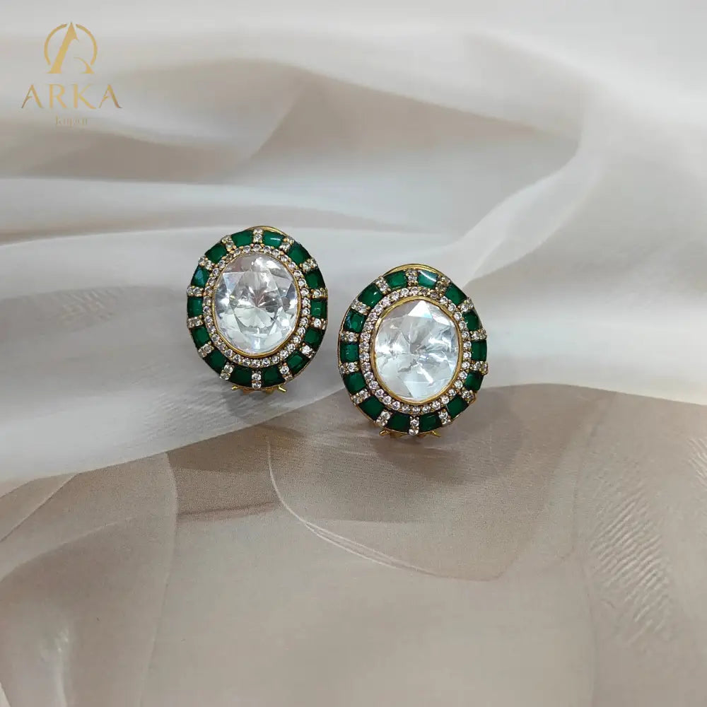 "Arka Jaipurs Eterna handcrafted Polki stud earrings with oval center stone, emerald-green halo, diamond accents, and gold-plated finish – heritage luxury jewelry."
