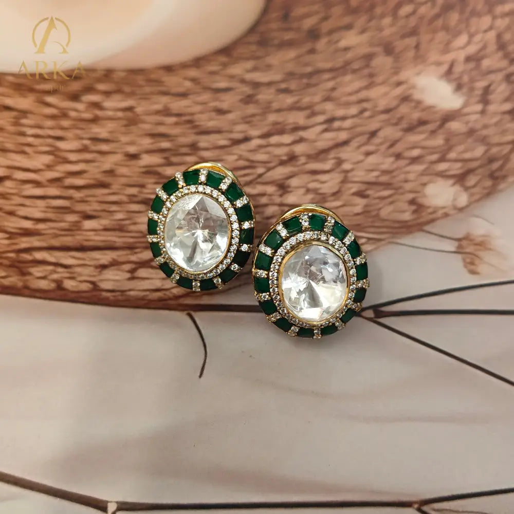 "Arka Jaipurs Eterna handcrafted Polki stud earrings with oval center stone, emerald-green halo, diamond accents, and gold-plated finish – heritage luxury jewelry."