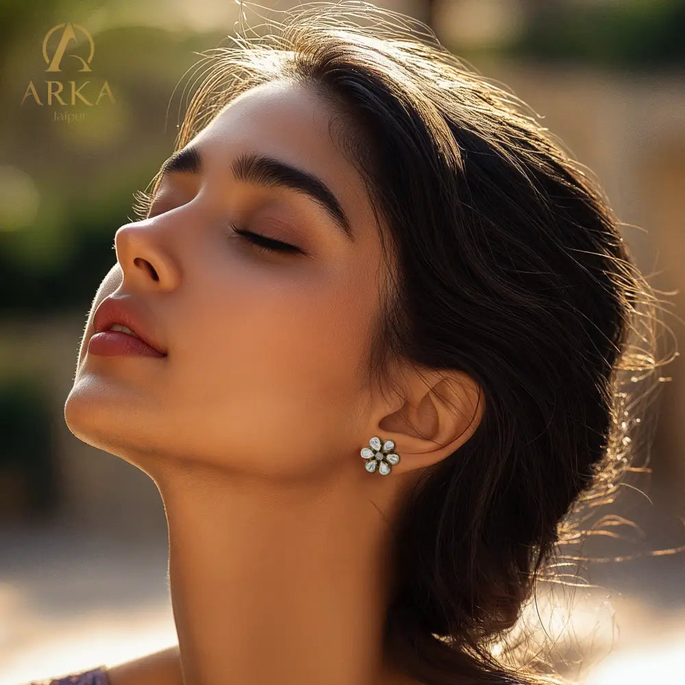 Floral-shaped Petal Radiance Stud earrings by Arka Jaipur, featuring six kundan-style petal stones with a central white stone in an antique gold setting