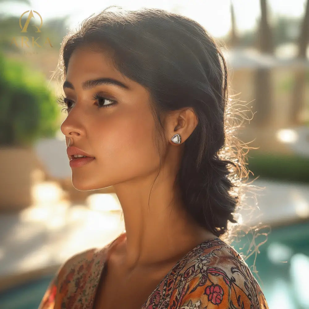 Model_with_dark_hair_pulled_back_wearing_triangular_stud_earrings_with_clear_stones_from_Arka_Jaipur_s_Neo_collection.