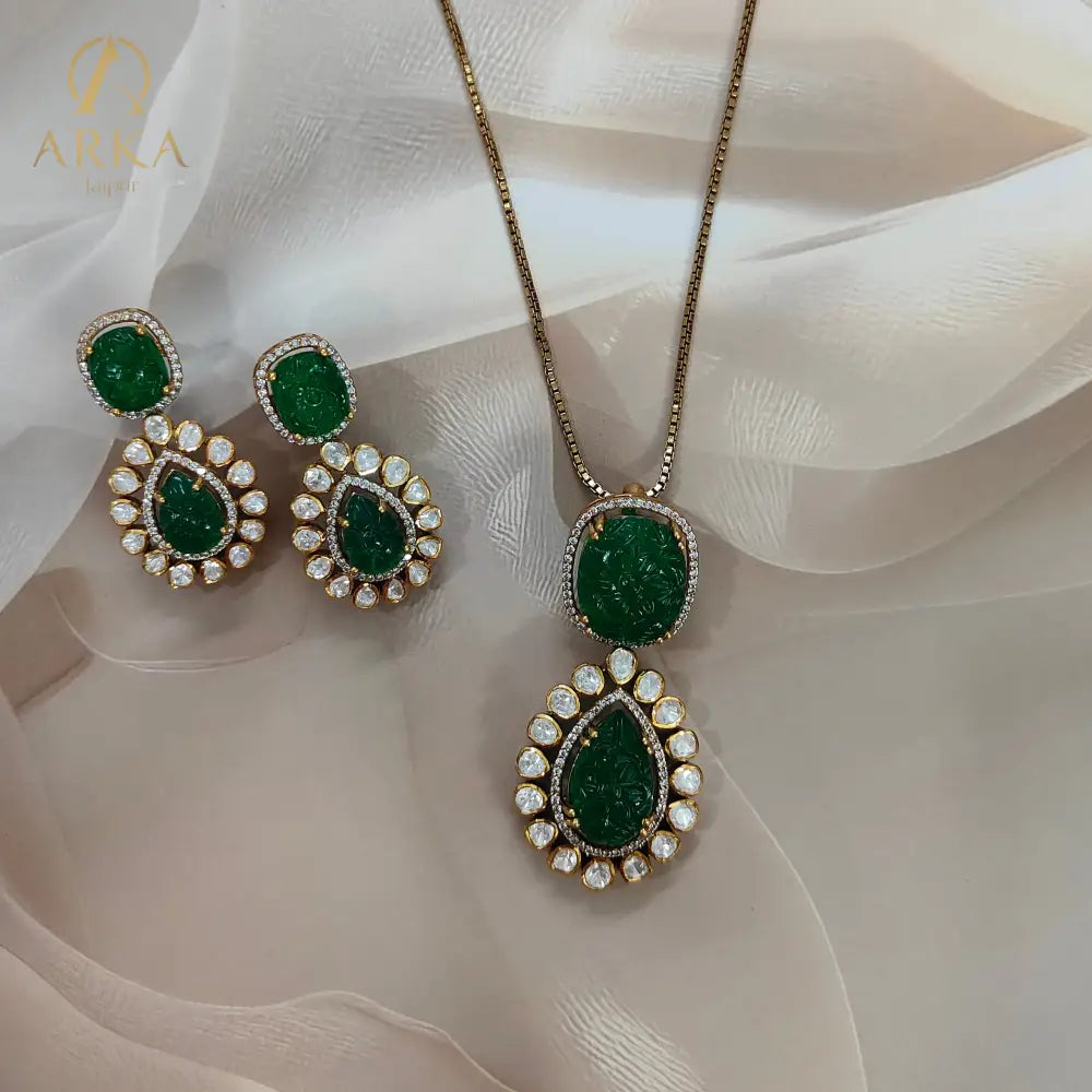 "Arka Jaipur Vintage Emerald Charm handcrafted Pendant Set with carved emerald green stones, Polki diamond halo, and gold finish – heritage inspired statement jewelry."