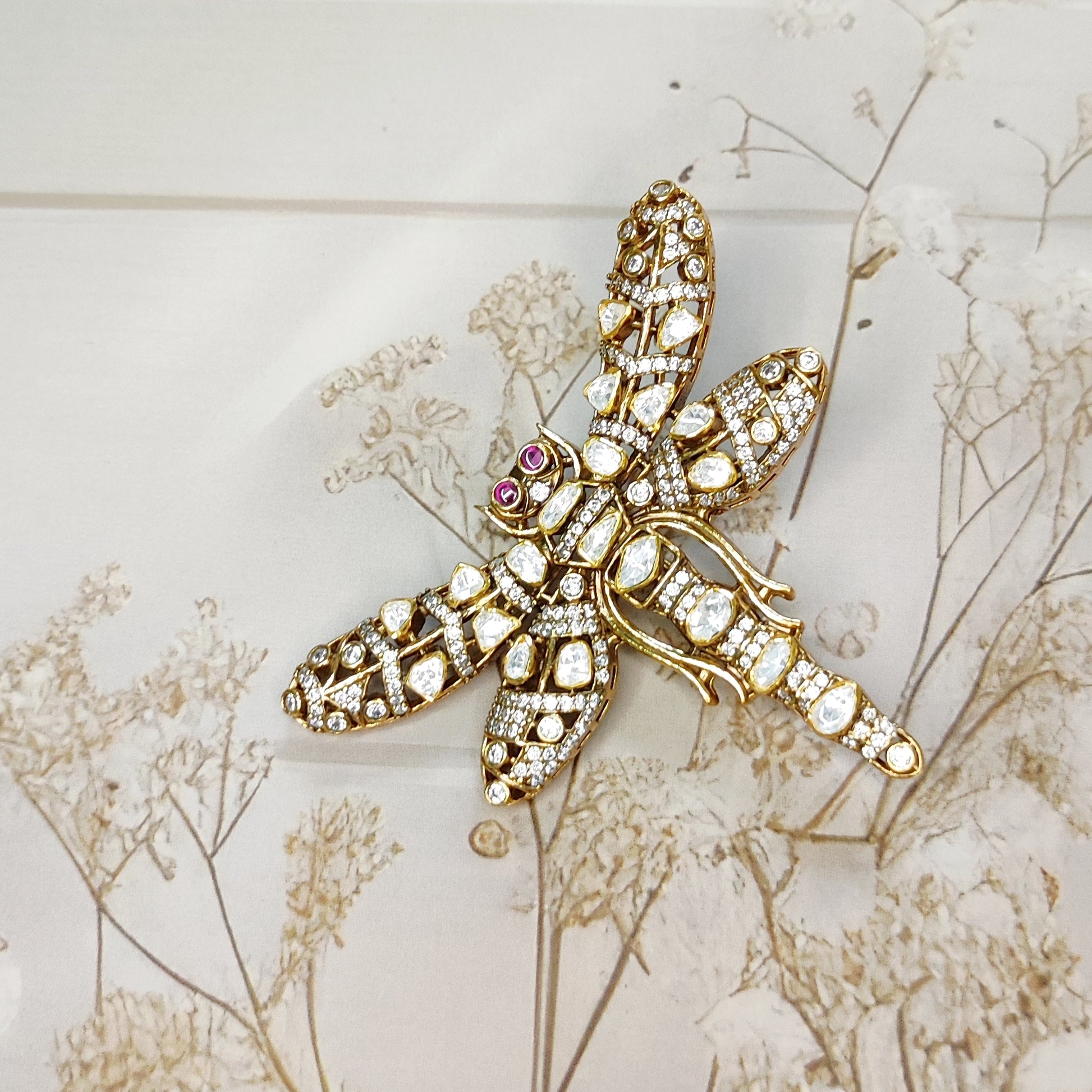 Handcrafted dragonfly brooch with uncut polki diamonds and ruby eyes by Arka Jaipur

Luxury gold dragonfly brooch inspired by Rajasthani architecture

Designer statement polki diamond brooch by Arka Jaipur

Heritage-inspired dragonfly jewelry brooch with rubies and polki