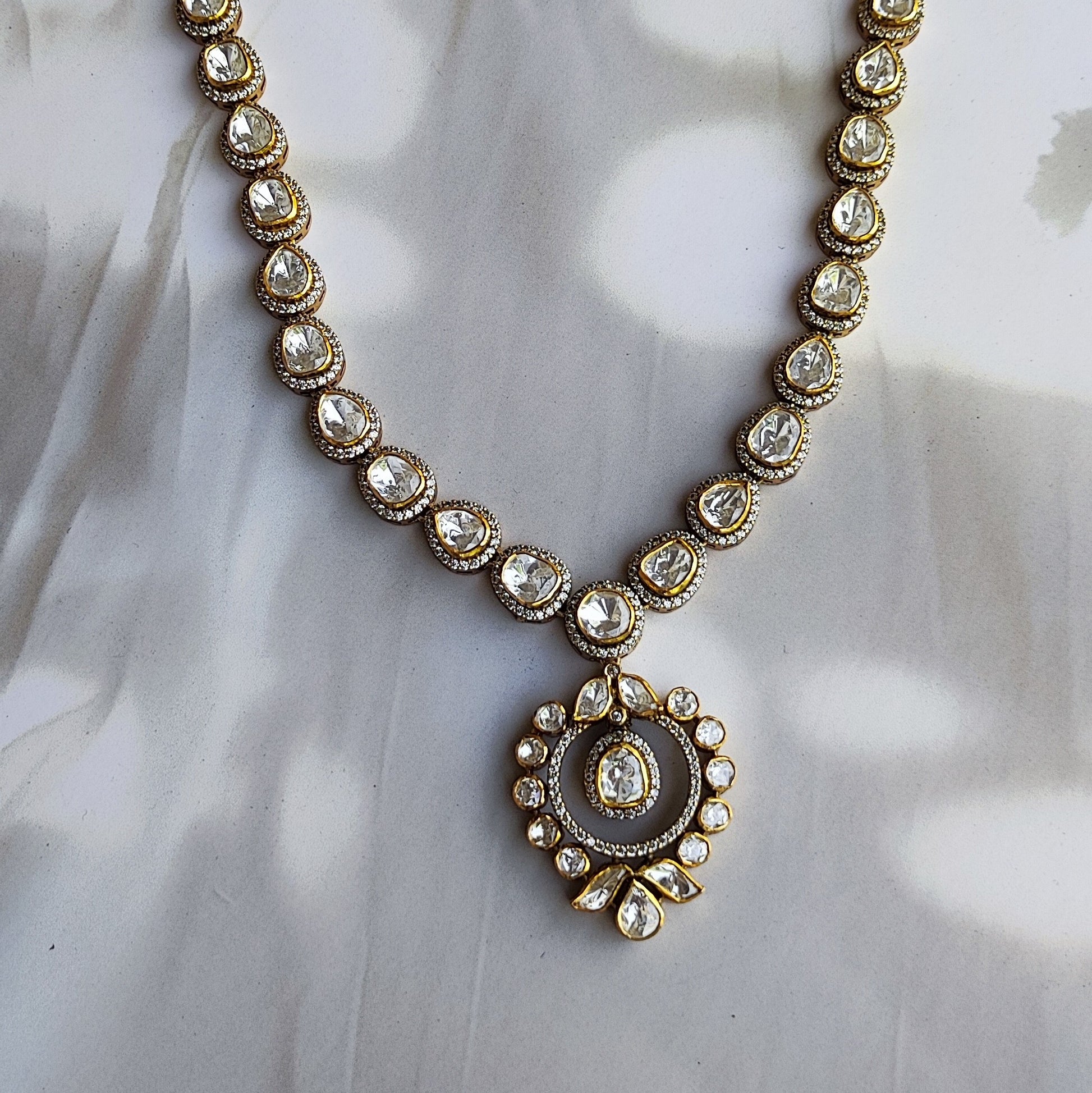 "Heritage Polki halo Necklace in gold polished silver with teardrop and round stons by Arka Jaipur","Traditional handcrafted Polki Necklace with CZ detailing from Arka Jaipur","Designer Indian Polki dangler earrings in circular halo design by Arka Jaipur"
