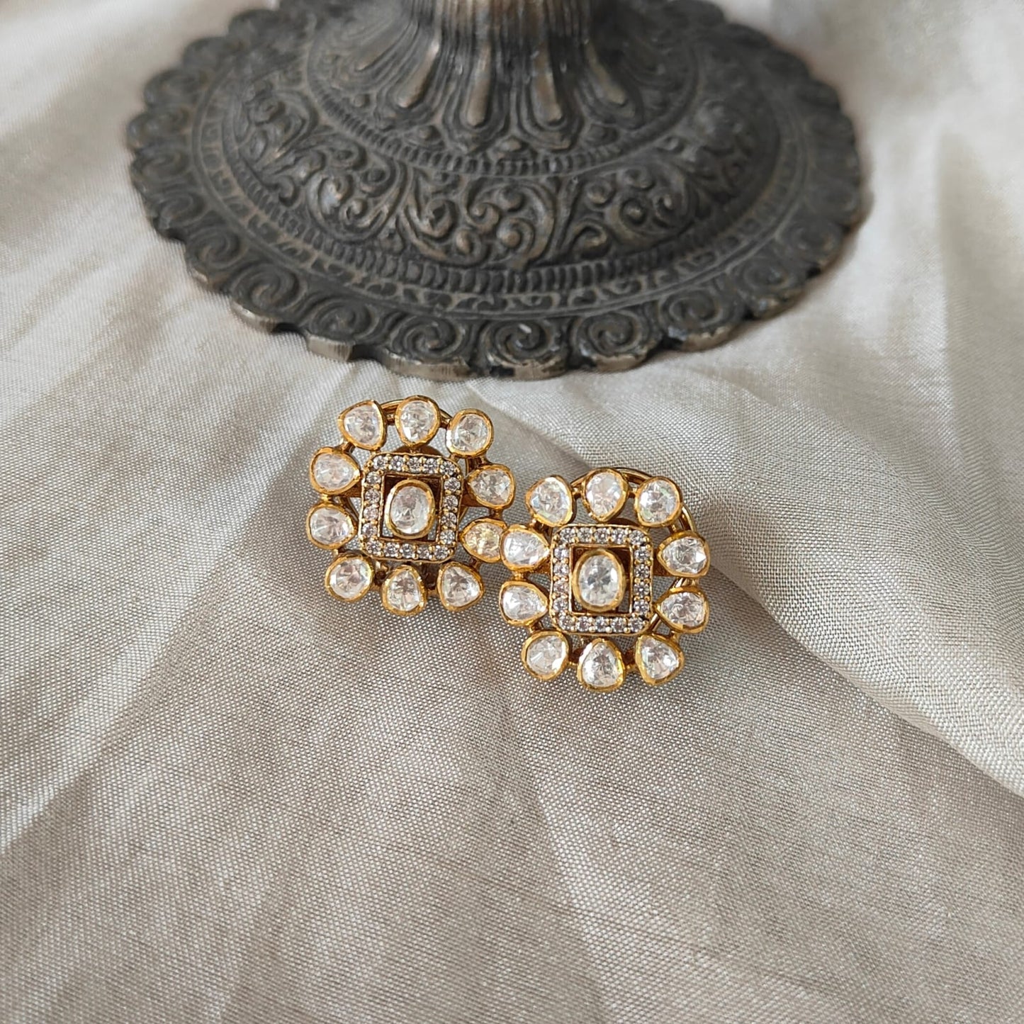 Ivory Halo Studs with square polki center and halo design in a luxury flatlay