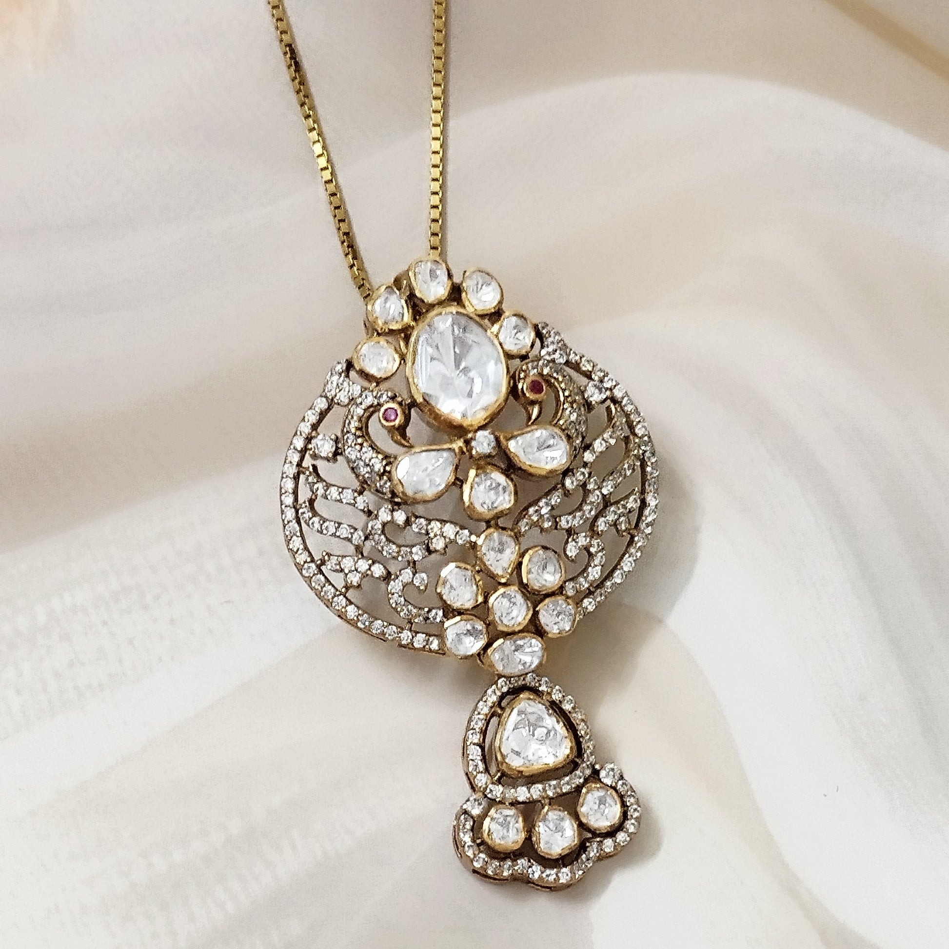 "Gold-plated polki Noor Classic Pendant with oval centerpiece and floral crystal design by Arka Jaipur", "Traditional kundan-style pendant with polki stones and ruby accents","Designer Indian pendant with floral motif and diamond-style detailing","Luxury heritage pendant handcrafted in Jaipur with polki and crystal work"