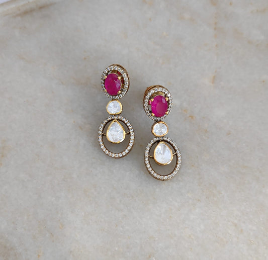 "Ruby Halo drop earrings handcrafted by Arka Jaipur featuring oval ruby color stone, pear-shaped Moissanite Polki stones and cubic zirconia in gold-plated setting"