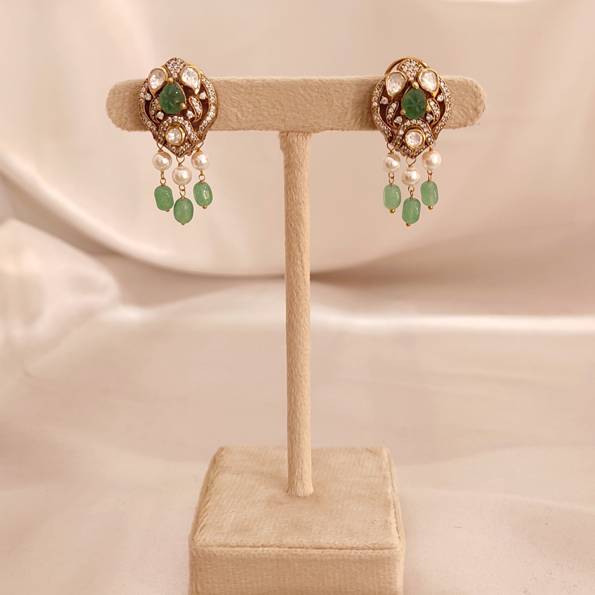 “Sanjh Emerald Earrings by Arka Jaipur featuring emerald-green stones, crystal accents, and intricate gold detailing in an elegant traditional jewellery design.”
