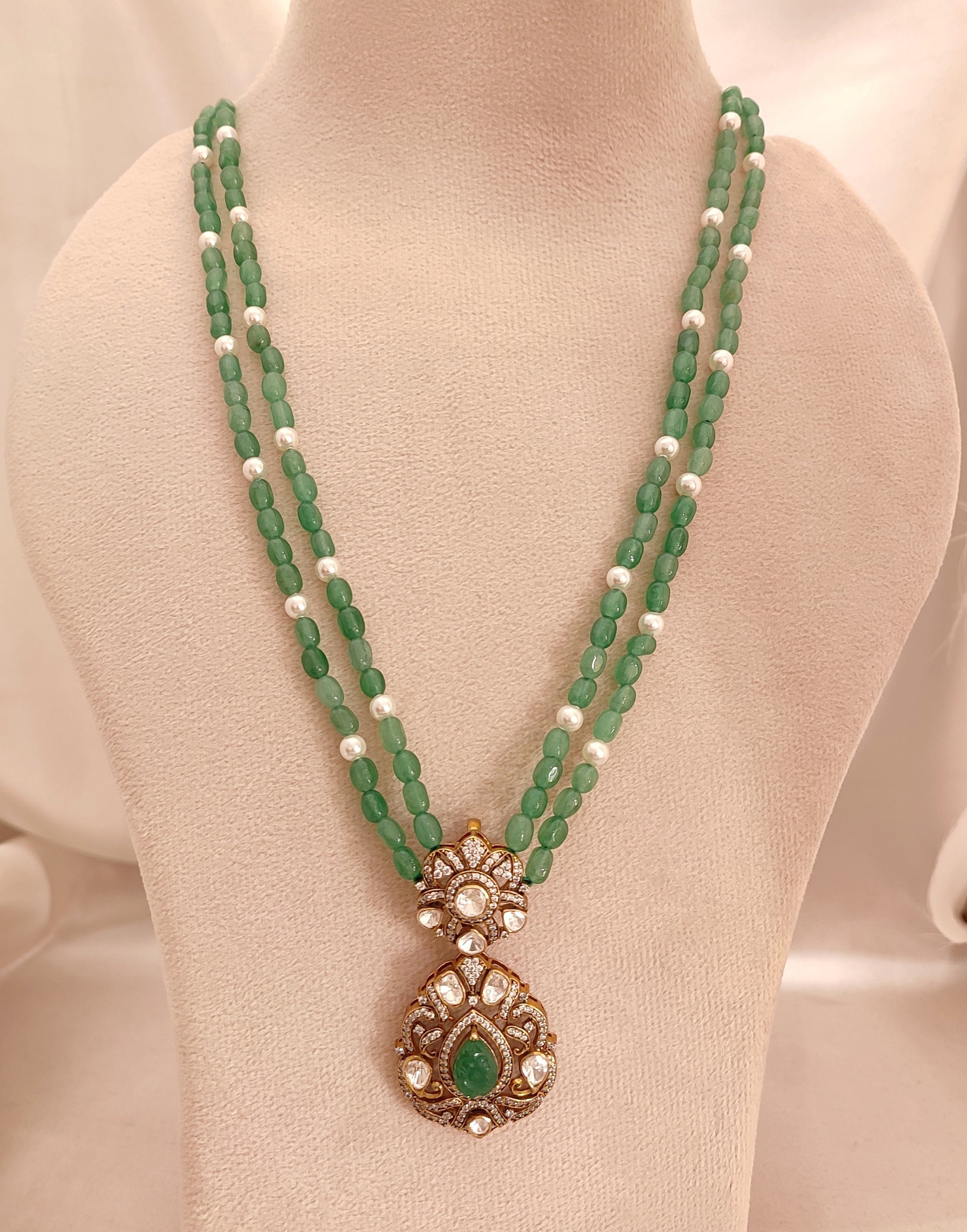 “Sanjh Emerald  Pendant by Arka Jaipur featuring emerald-green stones, crystal accents, and intricate gold detailing in an elegant traditional jewellery design.”