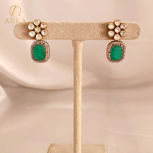 “Emerald Bloom earrings by Arka Jaipur – floral stud earrings with polki diamond cluster and rectangular emerald coloured drops set in gold plated silver with diamond outline.”