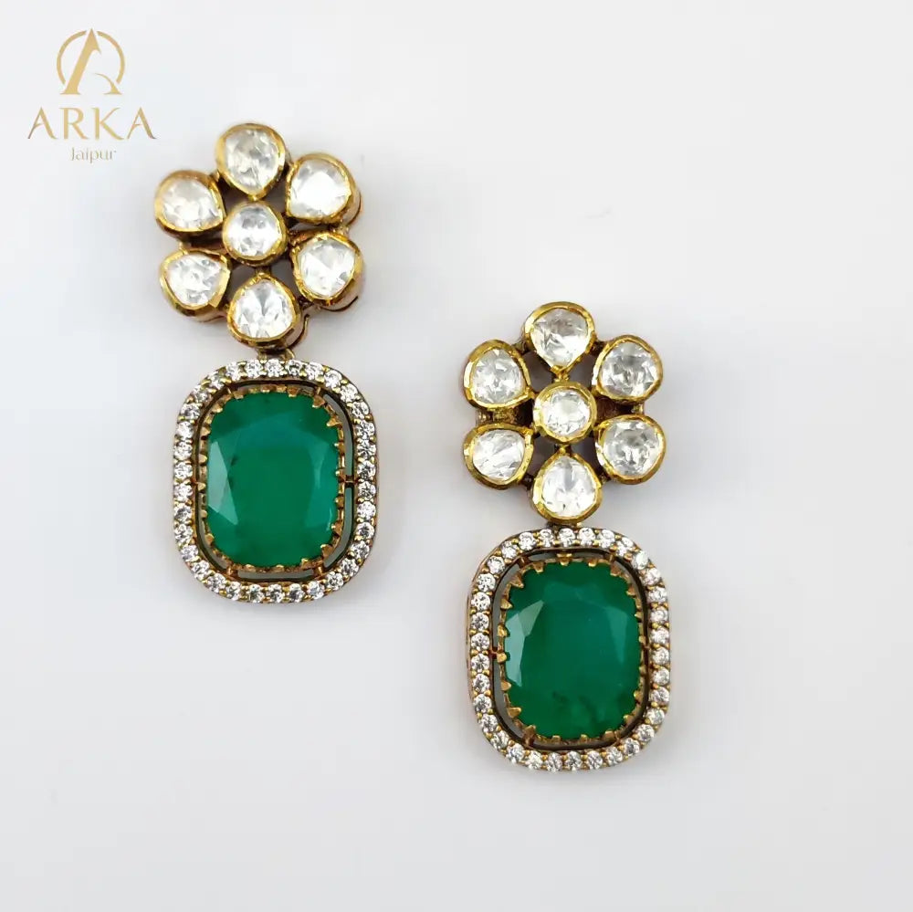 “Emerald Bloom earrings by Arka Jaipur – floral stud earrings with polki diamond cluster and rectangular emerald coloured drops set in gold plated silver with diamond outline.”