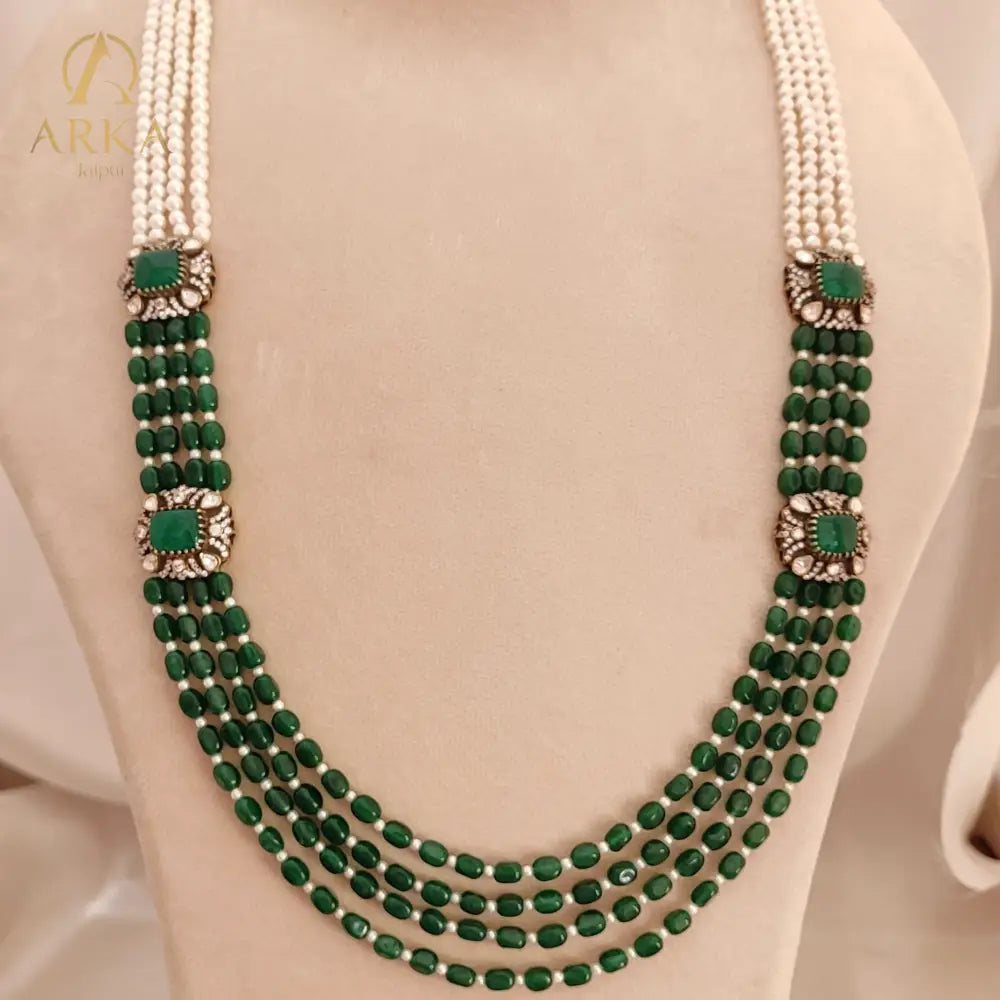 Emerald_Cascade ,Handcrafted green bead and pearl Kundan necklace by Arka Jaipur with traditional Rajasthani design, featuring five strands of green stones and white pearls with decorative square green Kundan connectors.