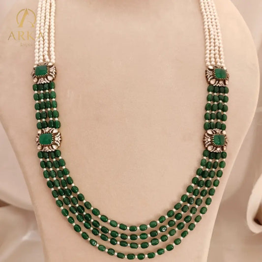 Emerald_Cascade ,Handcrafted green bead and pearl Kundan necklace by Arka Jaipur with traditional Rajasthani design, featuring five strands of green stones and white pearls with decorative square green Kundan connectors.