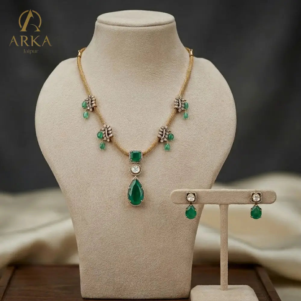 Emerald green sterling silver  Emerald Reverie Necklace and earring set with polki detailing and antique gold finish by Arka Jaipur.