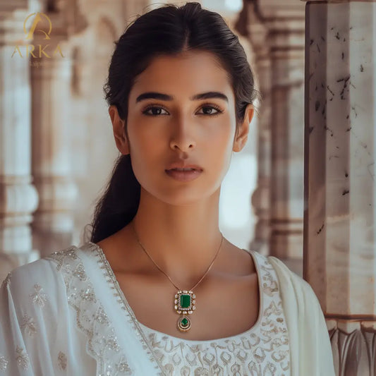 "Model wearing the Panna Vilas Pendant by Arka Jaipur — handcrafted gold-plated pendant with rich green gemstones and moissanite, perfect for royal weddings and festive celebrations."