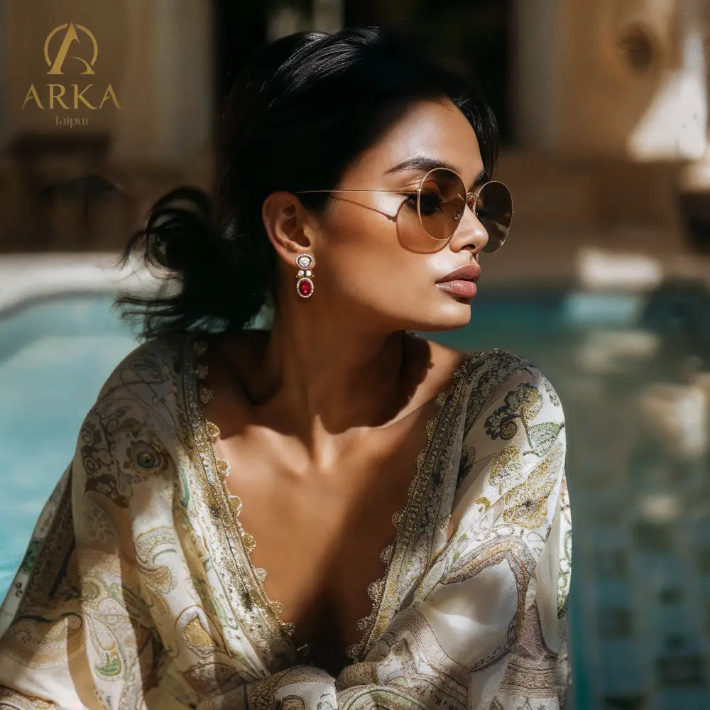 ElegantwomanbythepoolwearingRegalRubyearringsbyArkaJaipurhandcraftedmoissaniteandrubyredjewelryingold-platedsilver_perfectforluxurydestinationweddings.