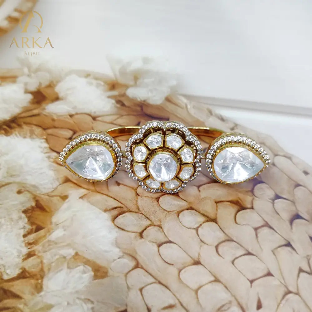 “Twin Bloom Ring by Arka Jaipur featuring a central floral polki design with two teardrop crystal motifs on each side, set in a gold finish, photographed on a soft neutral background with natural light.”